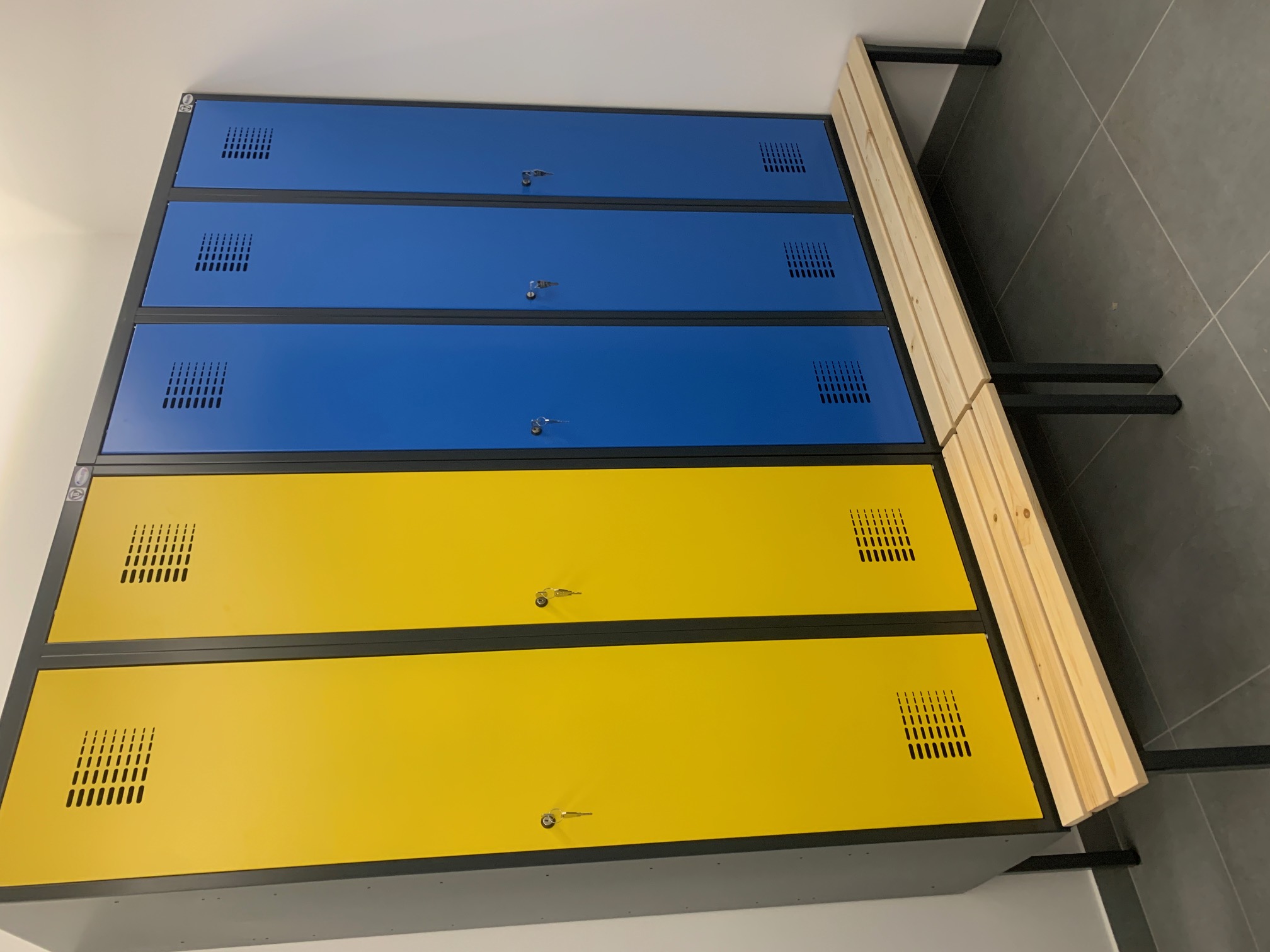 Metalowe szafy ubraniowe 80 i 120 cm z przegrodą na podstawie z siedziskiem, korpus RAL 9005, fronty RAL 1023 i RAL 5010 – realizacja Pozmebel Bydgoszcz